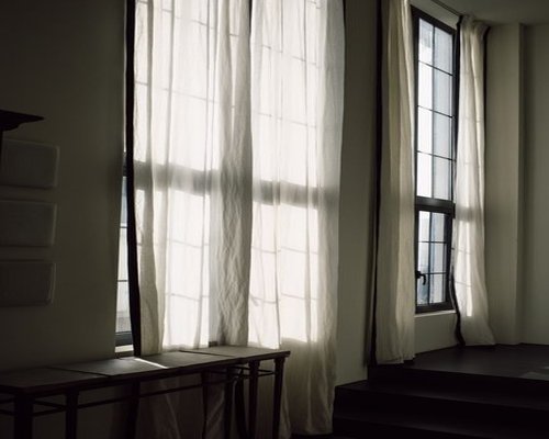 A desk placed thoughtfully near a window with soft natural light coming through sheer curtains
