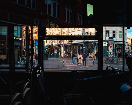 A view from inside a bus looking out onto a bustling city street at dusk, avoiding screen time
